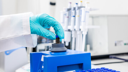 Close up of a woman shaking samples using a vortex mixer before HPLC analysis