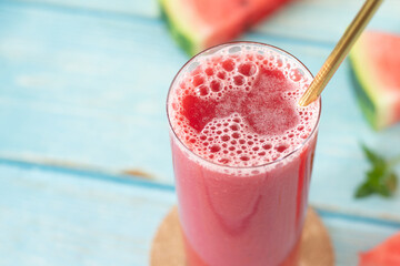Watermelon smoothie with mint in glass on wooden table. Close-up. Tropical summer juice, healthy...