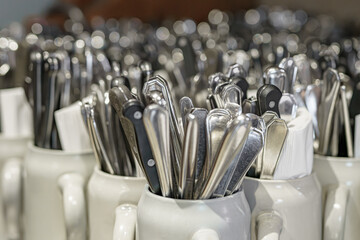 Clean spoons, forks and knives in the kitchen in a cafe. Cutlery in a restaurant.