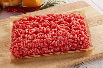 Raw minced beef meat over board