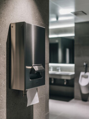 Modern Wall-Mounted Tissue Dispenser in Stainless Steel in a Commercial Restroom