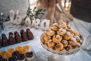 Pastry tower with cinnamon rolls and assorted desserts on table.