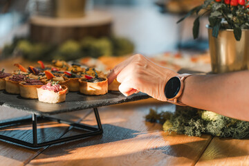 Hand reaching for appetizer at rustic buffet setup