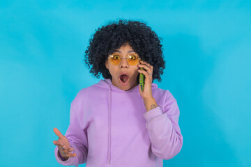 girl with sunglasses and mobile phone isolated with an expression of surprise or amazement
