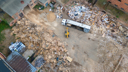 Drone photography of a telehandler removing wooden pallet from a truck during summer day