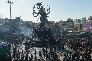 Fototapeta premium Vibrant Festive Celebration with Decorated Durga Idol in Crowded City Square - Perfect for Event Posters and Cultural Design Projects