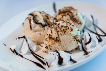 Ice cream with fruits and chocolate on a white plate