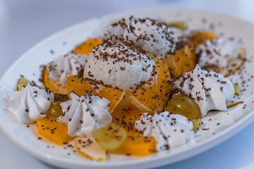 Ice cream with fruits and chocolate on a white plate