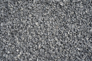 Gray background with crushed stone. Small broken stone with sharp edges, several shades of grey, as a substrate for graphics and design. Place, space for text.