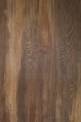 Wooden background. Aged lacquer board, lacquer finish, surface, several tones of brown. Close-up, vertical photo, image.
