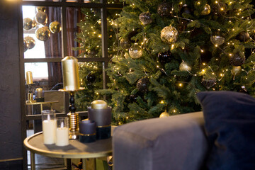 Christmas interior with a beautiful Christmas tree, sofa, light bulbs and dark background.
