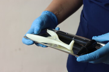 Professional wearing gloves holding a tray with nasal speculum and a otoscope with copy space 