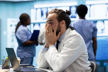 Frustrated and worried medic reading the diagnosis on test results, working under pressure to find...