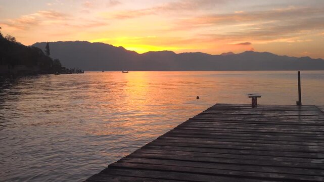 On a dock on Lake Atitl&aacute;n during a beautiful sunrise with birds swimming and fisherman fishing 