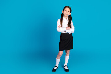 Full size photo of cute small schoolkid crossed arms empty space wear uniform isolated on blue...