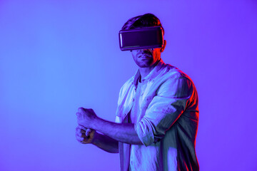Caucasian man wearing VR glass and moving gesture holding sword. Gamer using future digital virtual reality headset or futuristic innovation to enter meta world or playing action game. Deviation.