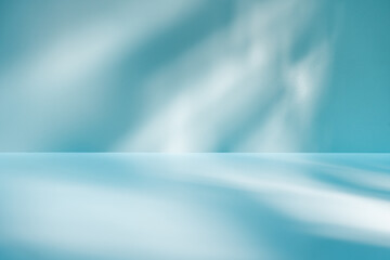 Light background with light and shadows on blue wall. Panoramic abstract background for product presentation.