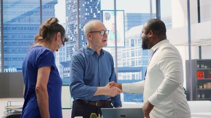 Senior citizens greeting banker to explore various retirement planning options, ensuring they make informed decisions about future financial stability. Consulting a financial advisor. Camera A.