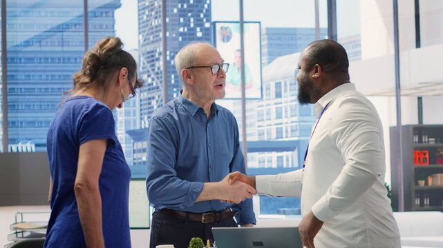 Senior citizens greeting banker to explore various retirement planning options, ensuring they make informed decisions about future financial stability. Consulting a financial advisor. Camera A. - Powered by Adobe