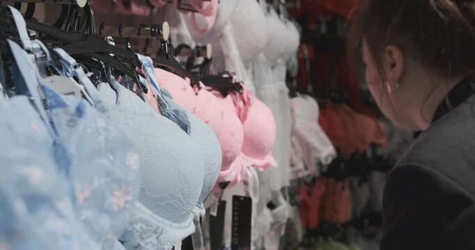 woman admires beautiful lace lingerie in store carefully examining allure of intimate apparel showcasing the delicate designs elegance perfect for enhancing one's wardrobe stylish lingerie choices