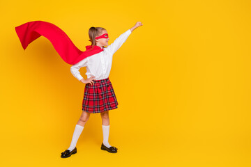 Full body photo of small schoolchild superhero costume uniform raise fist empty space isolated on yellow color background