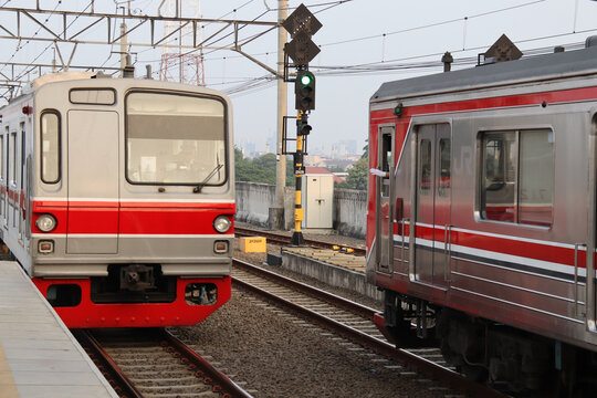 A dynamic capture of Jakarta's Commuter Line trains at a station platform, highlighting the urban rail transit system. Perfect for themes of public transportation, city life, and infrastructure