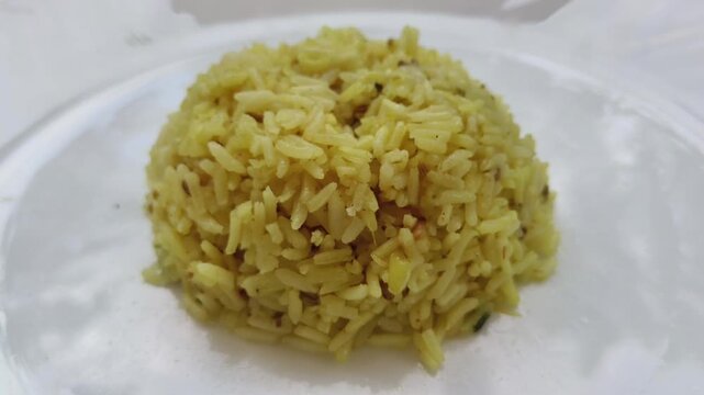 Cooked basmati rice biriyani served and isolated on a white plate background with copy space. Beautiful closeup macro 4k top view of popular dish, food or cuisine.