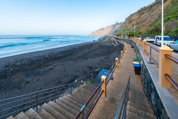 Obraz premium A black volcanic sand beach along the north coast of the Canary Island of Tenerife at the town of Puerto de la Cruz, Spain.
