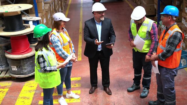 Effective Management in Action: Businessman Engaging and walking with Warehouse Worker and Engineer, Utilizing Digital Tablet	