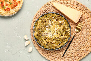 Plate of tasty Italian pasta with Parmesan cheese on light background