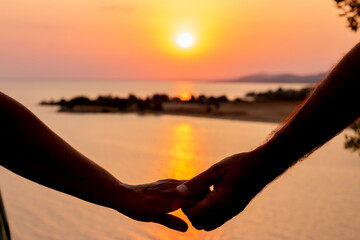 Couple in love with hands holding hands at sunset