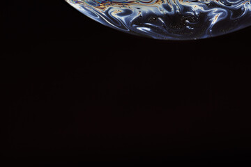 Soap bubble. Abstract background. Space model. Streaks of fluid. Surface with psychedelic colors. Virtual reality planet. Free space for an inscription. Conceptual image of the universe.