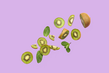 Fresh cut kiwi and mint leaves flying on lilac background
