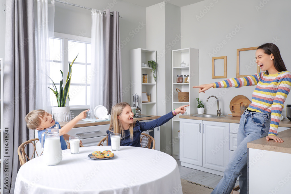 Wall mural Happy family with glasses of milk and cookies at dining table in kitchen