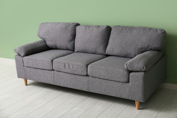 Cozy sofa near green wall in stylish living room