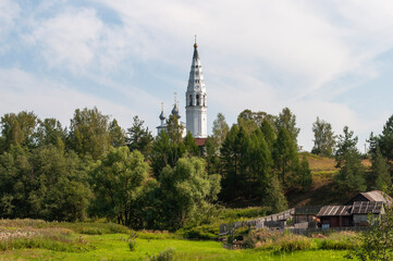 Summer rural landscape with ancient church in the background. Cathedral of the Transfiguration of the Savior in Sudislavl, Kostroma region, Russia