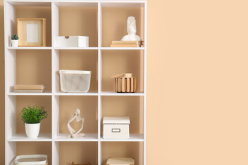 Shelving unit with decoration near beige wall
