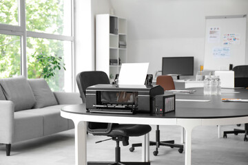 Modern printer on table in stylish office