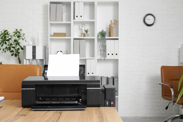 Modern printer on wooden table in stylish office