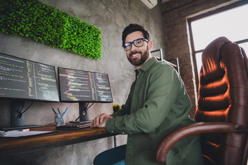 Photo of professional it specialist young man sit chair computer desktop loft interior office...