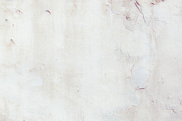 White plaster wall with natural defects. Fragment of the grunge surface. Natural cracked cement on...