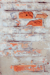 Old grungy red brick wall. Free space for an inscription. Fragment of a wall with bumps and peeling paint.