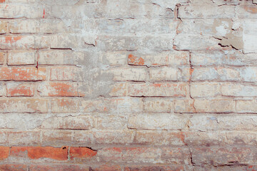White old grungy brick wall. Fragment of a wall with bumps and peeling paint. Restoration of semi-antique brick walls. A basic neutral background for a design project.