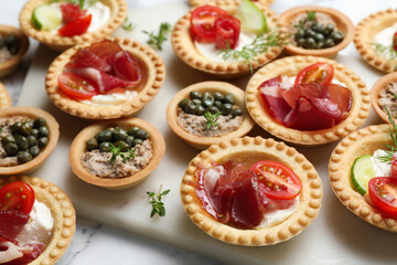 Different delicious canapes on white table, closeup