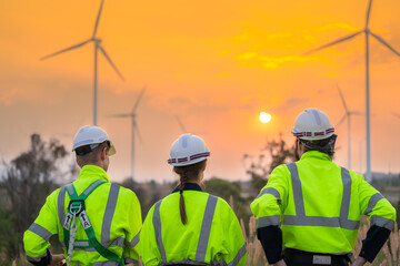 Team Engineers men and woman checking and inspecting on construction with sunset sky. people operation. Wind turbine for electrical of clean energy and environment. Industrial of sustainable.