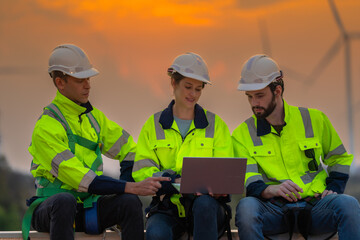 Team Engineers men and woman checking and inspecting on construction with sunset sky. people operation. Wind turbine for electrical of clean energy and environment. Industrial of sustainable.