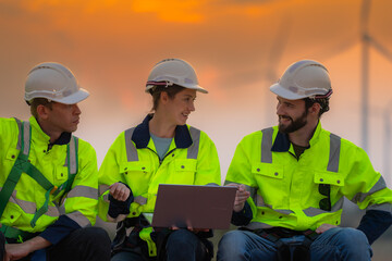 Team Engineers men and woman checking and inspecting on construction with sunset sky. people operation. Wind turbine for electrical of clean energy and environment. Industrial of sustainable.