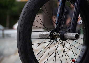 Close-up of bicycle wheel with blurred background. Close-up of part of tire and stems.