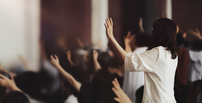 Passionate Christians with hands raised in prayer, Holy Spirit filled worship and church setting
