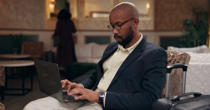 Businessman, laptop and suitcase for travel in first class lounge for networking, email and connection. Black, male person and tech in typing for meeting as international relations officer in airport